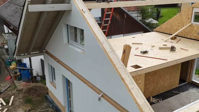 Dachkonstruktion eines Holzständerhauses mit montierten Außenwänden – Aufbauphase durch HT Scherer BAUprojekt