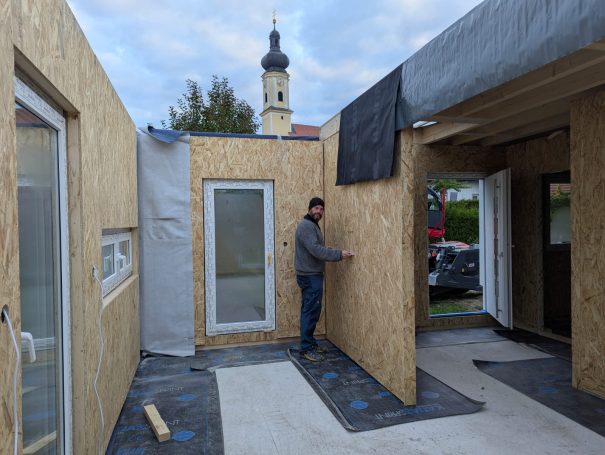 Montage der Außenwand eines Holzständerhauses auf der Bodenplatte – präzise Bauausführung durch HT Scherer BAUprojekt