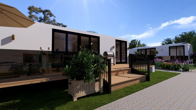 Moderne Wohnhäuser mit Terrassen und bepflanzten Bereichen unter blauem Himmel.