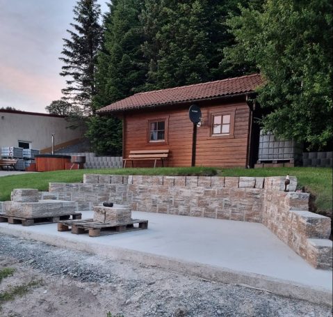 Fertige Bodenplatte mit Granit-Stützwand auf einem Baugrundstück – HT Scherer BAUprojekt