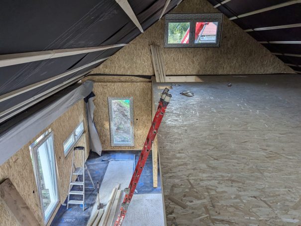 Obergeschoss eines Holzständerhauses während der Bauphase – Innenausbau mit sichtbarer Tragkonstruktion