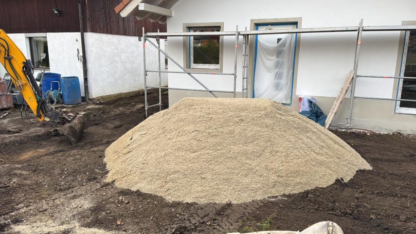 Gelieferter Sandhaufen vor dem Haus für das Verlegen des Estriches