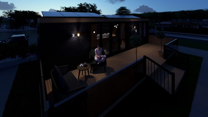 Mann sitzt auf einer Terrasse bei Nacht, umgeben von Schatten und sanftem Licht.